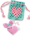 Crocheted heart-shaped pouch with pink heart keychain on a white background